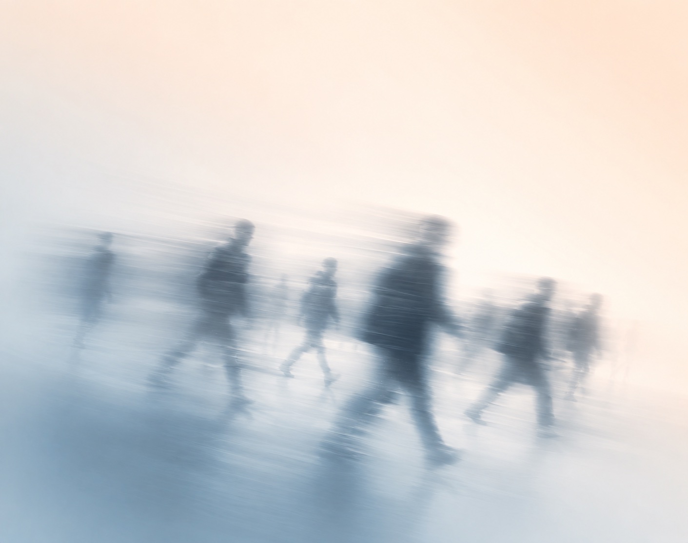 A crowd walking, in peach and blue-grey light